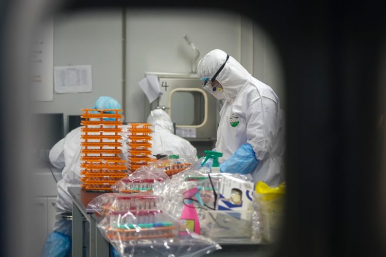 This Saturday, Feb. 22, 2020, photo released by Xinhua News Agency, shows medical workers in protective suits at a coronavirus detection lab in Wuhan in central China's Hubei Province. The fresh national figures for the disease that emerged in China in December came as the number of viral infections soared mostly in and around the southeastern city of Daegu, where they were linked to a local church and a hospital. (Cheng Min/Xinhua via AP)